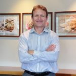 Tru-Cape Managing Director Roelf Pienaar pictured in front of images from our recipe book, Too Good to be True.